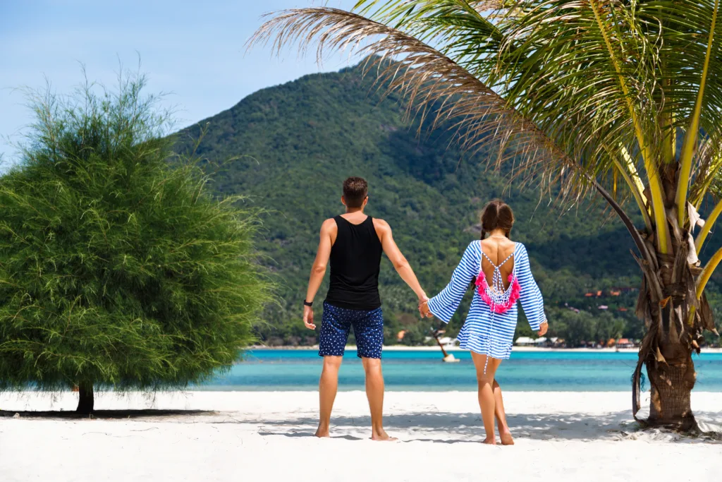 Portrait of pretty romantic couple having fun at tropical islands, handsome man and pretty  girlfriend, wearing cute bright beach dress, Maldives paradise vacation. Amazing view, travel expirience.