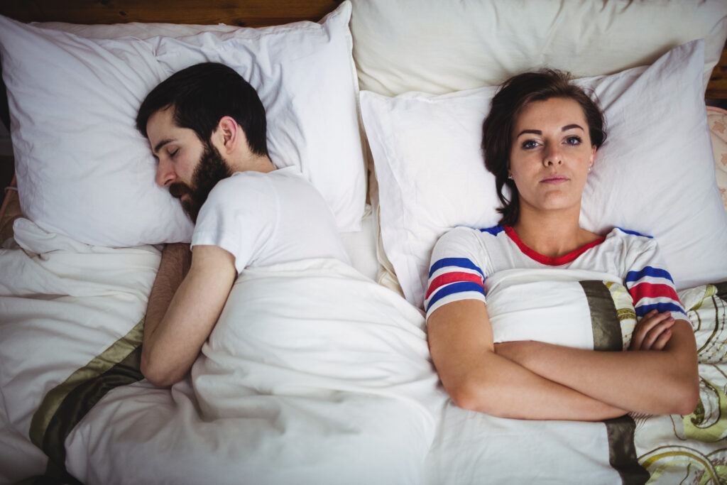 Portrait of woman lying on bed at bedroom