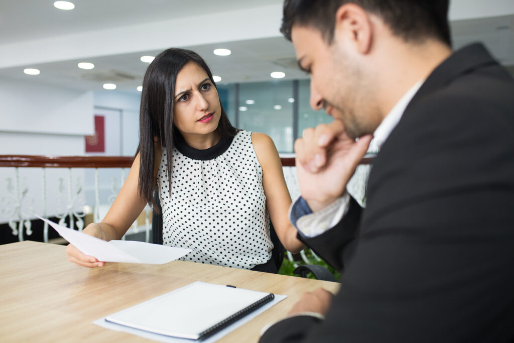 Upset business lady dressing down employee for mistakes in report. Displeased businesswoman talking to colleague in office. Meeting concept